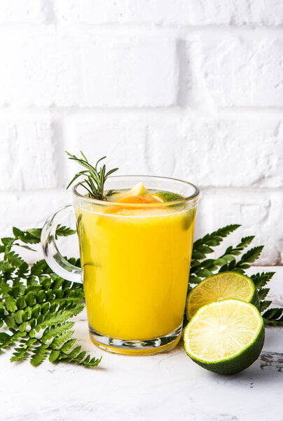 горячий лимонный чай с лаймом в стакане на белом фоне стены
