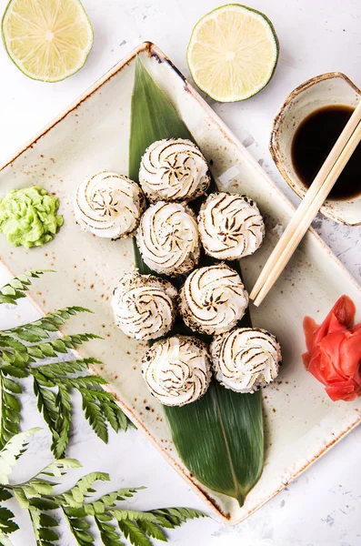 sıcak fırında Japonca krem peynir ile chopsticks ve beyaz arka plan üzerinde soya sosu ile bambu yaprak üzerinde rulo