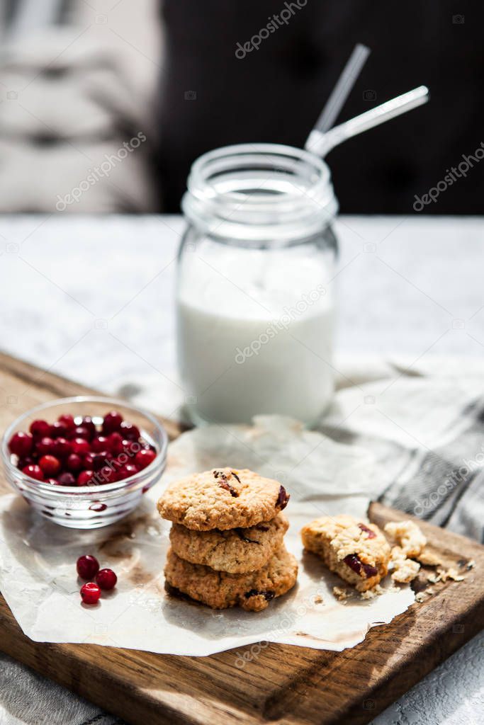 Pumpkin, oat cookies with cranberries on wooden background