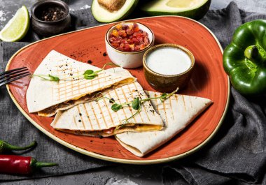 Avokado, biber ve limon ile servis içinde beton gri arka plan üzerinde quesadilla Meksika yemeği