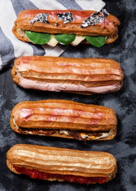 Peynir, ıspanak koyu gri arka plan üzerinde jambon, kırmızı havyar ile farklı tuzlu eclaires