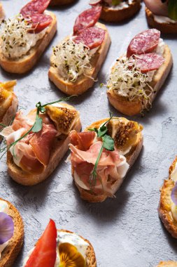 Bruschetta et ve peynirle gri beton zemin yakın çekim üzerinde farklı türleri