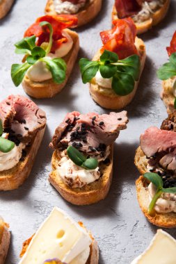 Bruschetta et ve peynirle gri beton zemin yakın çekim üzerinde farklı türleri