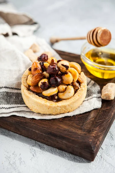 Delicious nutty dessert with honey and shortbread dough on a wooden board