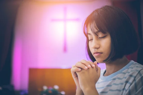短发少女亚洲她坐在教堂内 交错的手和眼睛祈祷上帝的祝福 背景有一个十字架作为基督的象征与复制空间 — 图库照片