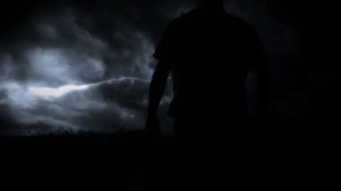 Dalgalı tişörtlü adamın silueti gök gürültüsüyle gökyüzüne çıkıyor.