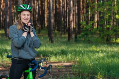 Bir bisiklet park gri kapşonlu kız. Bir bisiklet yarışı. Aktif bir şekilde yaşam ve spor oynarken.
