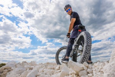  Bir bisikletçi kireçli ocağında eğitim. Şişman bisikletle acımasız bir adam.