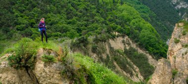 Dağlarda bir sırt çantası ile kız. Dağ yolda trekking.