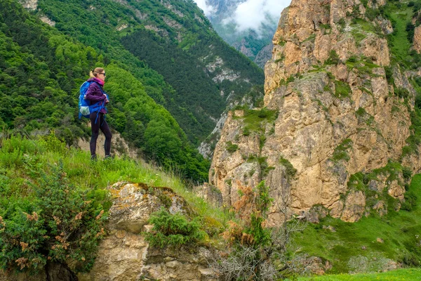 Dağlarda bir sırt çantası ile kız. Dağ yolda trekking.