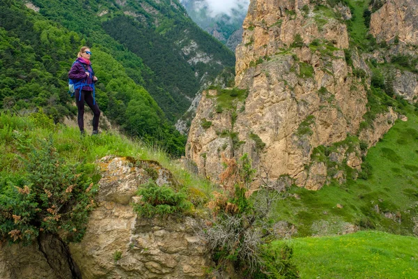 Dağlarda bir sırt çantası ile kız. Dağ yolda trekking.