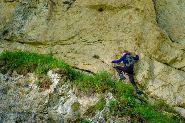 Girl mountaineer in the mountains. Climb to the mountain top.