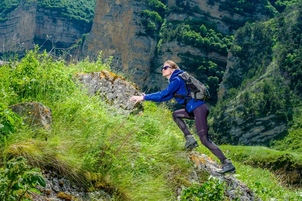 Girl mountaineer in the mountains. Climb to the mountain top.