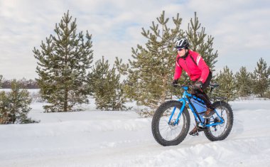 Fat biker riding his bicycle in the snow during winter. Fat bike. clipart