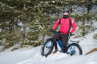 Kışın şişman bisiklete binen genç bir adam. Şişko bisiklet..