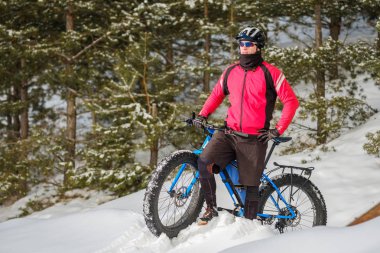 Kışın şişman bisiklete binen genç bir adam. Şişko bisiklet..