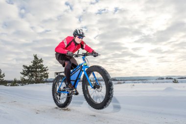 A young man riding fat bicycle in the winter. Fat tire bike. clipart