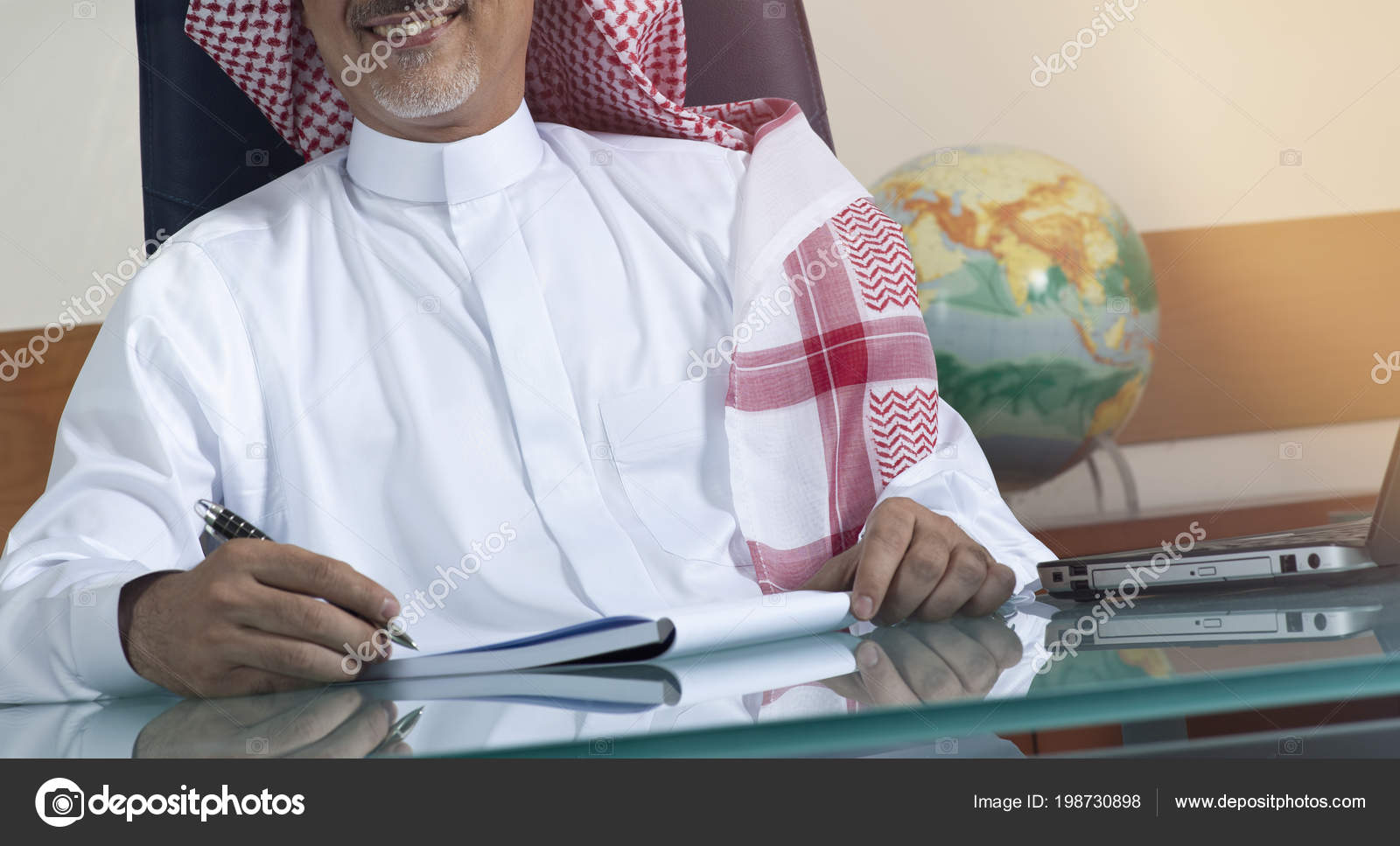 Senior Saudi Businessman Hand Writing His Desk Laptop Stock