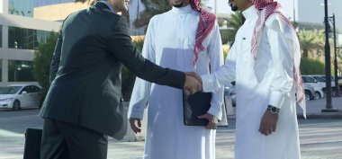 Orta Doğu ve Kafkas işadamları açık güneşli bir günde tokalaşırken