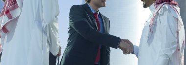 Orta Doğu ve Kafkas işadamları açık güneşli bir günde tokalaşırken