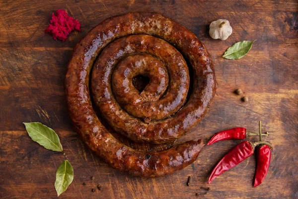 Eski bir fırında pişmiş sarmal sosis biber ve sarımsak ile ahşap bir gemide halkasıdır