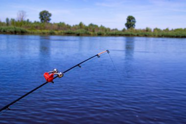 Nehri üzerinde bir besleyici ile Balık tutma bir çan olan nehir kıyısındaki bir yem attı
