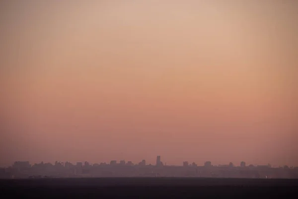 Noite por do sol sobre um grande sity com maçante vermelho noite céu — Fotografia de Stock