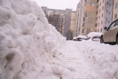Kar kaplı çok öykülü bina ve araçların arka planı yoğun kar yağışı sırasında yolda arabadaki yollar basmak
