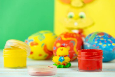 Bebek tavuk, boya ve fırça ile çok renkli ahşap arka plan üzerinde Paskalya yortusu yumurta