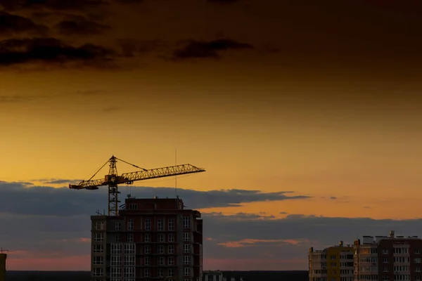 Industrial construction cranes on amazing sunset sky background