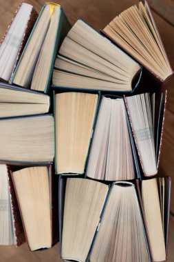 Pek çok kitap yığınları. Ahşap masa ciltli kitaplar.