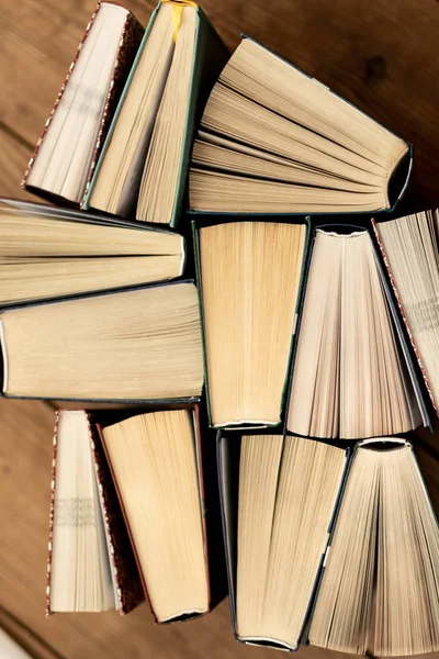 Mnoho knih piloty. Vázané knihy na dřevěný stůl. — Stock fotografie
