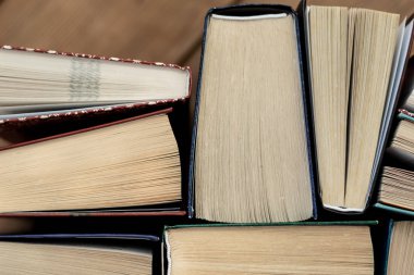 Pek çok kitap yığınları. Ahşap masa ciltli kitaplar.
