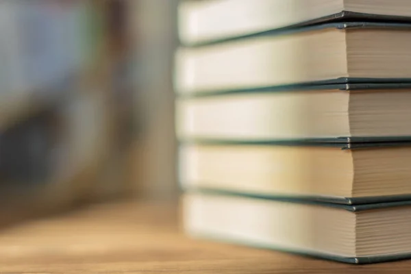 Pila de libros en el escritorio en la sala de la biblioteca bajo los rayos del sol — Foto de Stock