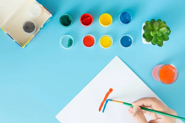 Primer plano del artista con paleta y pintura de pincel bodegón en papel en el estudio pintura a mano línea roja y azul — Foto de Stock