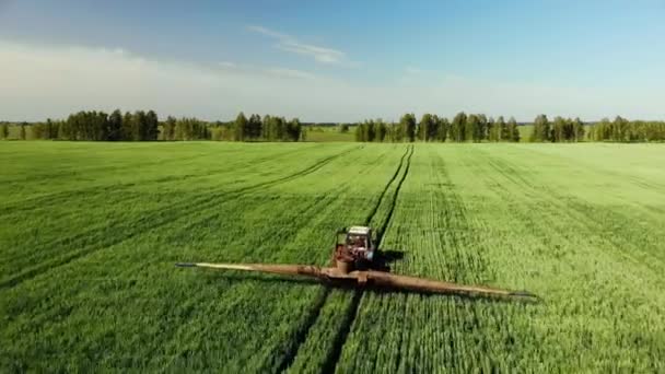 Vista aérea del tractor agrícola arando y pulverizando en el campo — Vídeos de Stock