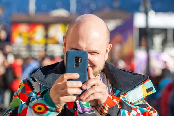 Чоловік в куртці фотографує пейзаж по телефону — стокове фото