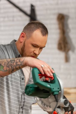 Man sawing wood with a circular saw on a workbench