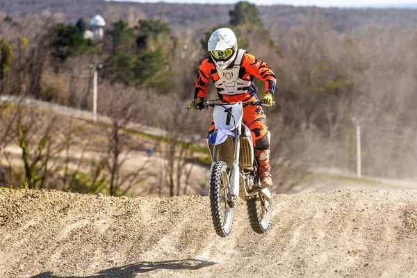 Professional Motocross Motorcycle Rider Drives Through Smoke and Mist Over the Dirt Road Track.