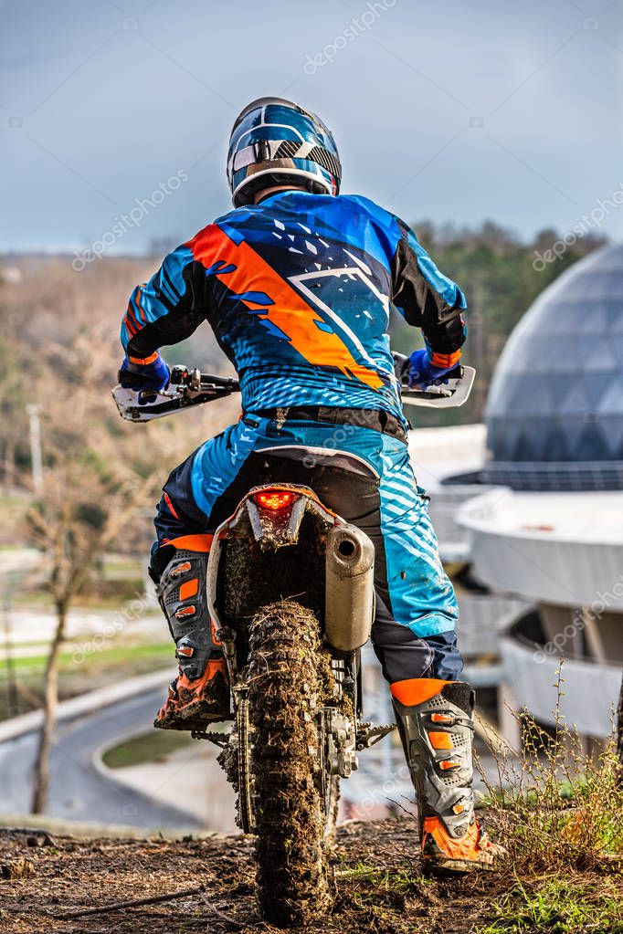 Fotos de Hombre montando un motocross en un traje protector en el barro -  Imagen de © Gerain0812 #196964644