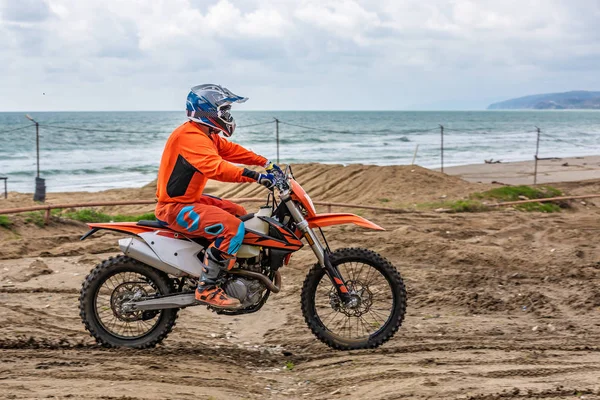 Motorcyklist i en skyddsdräkt på motorcykel framför havet — Stockfoto