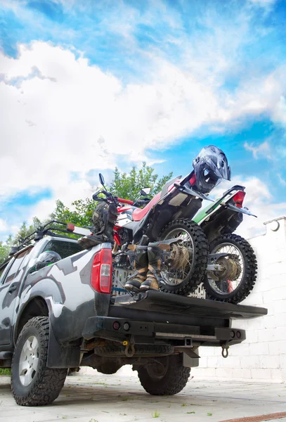 Two dirt bike motorcycles on the back of the camo truck with saf — Stock Photo, Image