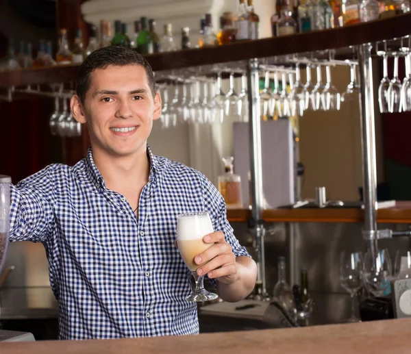 Усміхнений красивий бармен стоїть за барною стійкою і h — стокове фото