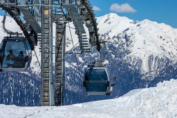 Ski lift with seats going over the mountain and paths from skies and snowboards — Stock Photo, Image