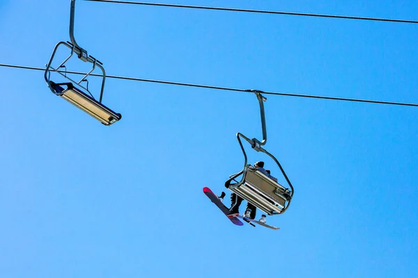Remontées mécaniques avec sièges surplombant la montagne et sentiers depuis le ciel et le snowboard — Photo