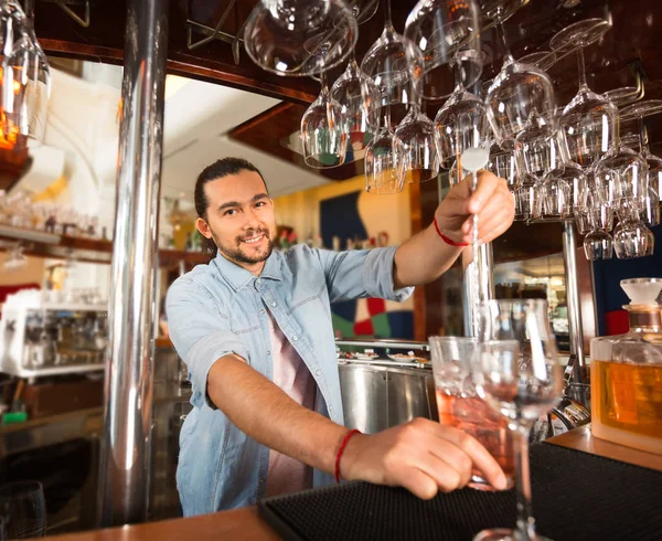 Pohledný mladý usmívající se barman připravuje alkoholický nápoj. — Stock fotografie