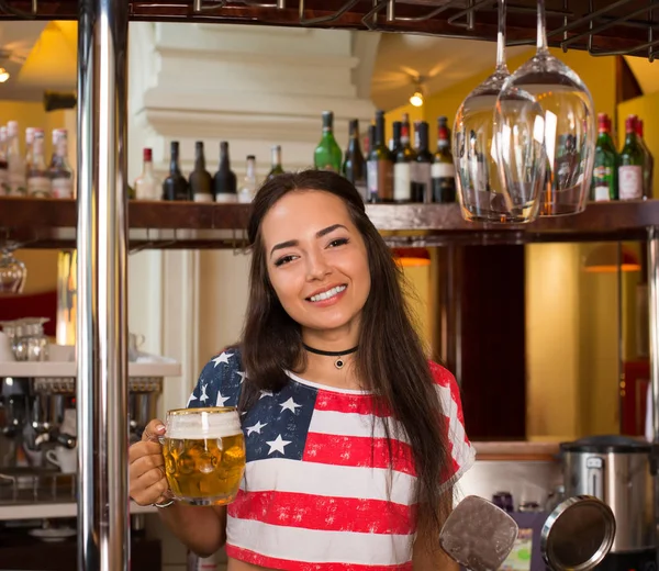 Молода весела щаслива дівчина бармена тримає великий кухоль з пивом . — стокове фото