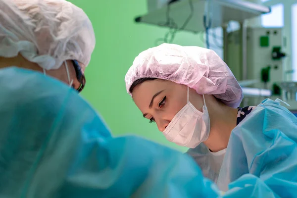 female surgeon doctor or intern wearing protective mask and hat.