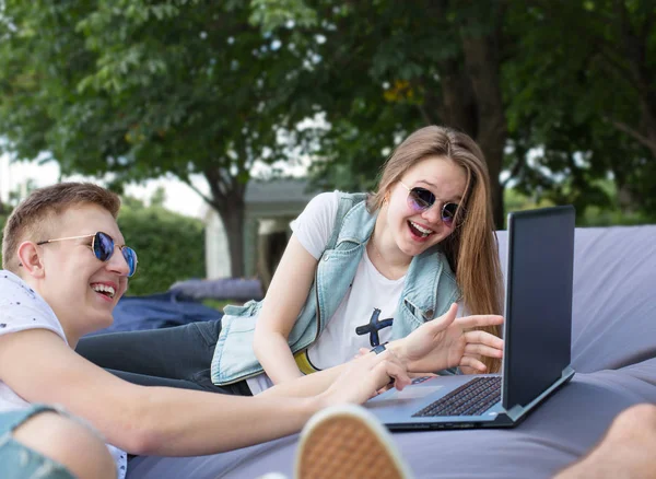 Счастливая Молодая Пара Солнечных Очках Лежит Большой Подушке Ноутбуком Имеющим — стоковое фото