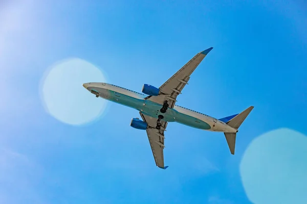 日光光線の青い空を飛んでいる旅客機 — ストック写真